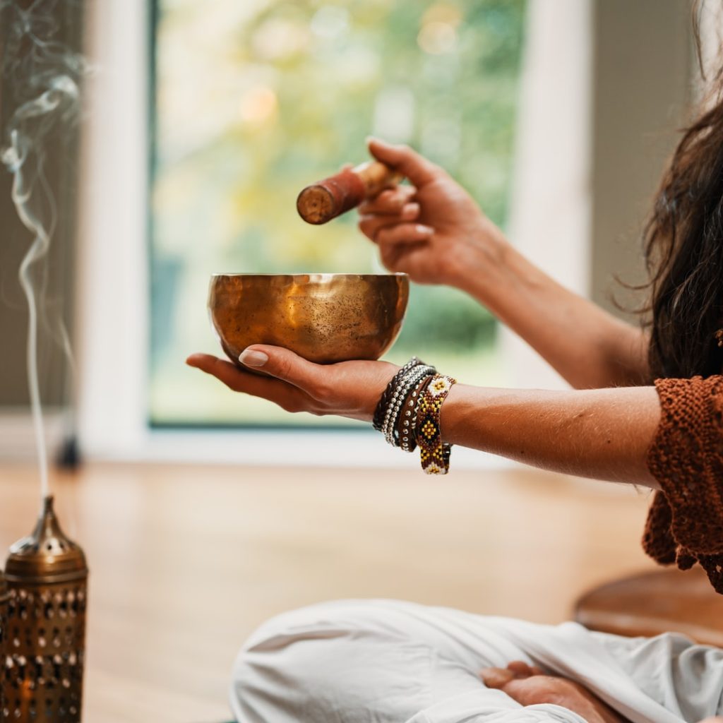 woman in brown knit sweater holding brown ceramic cup